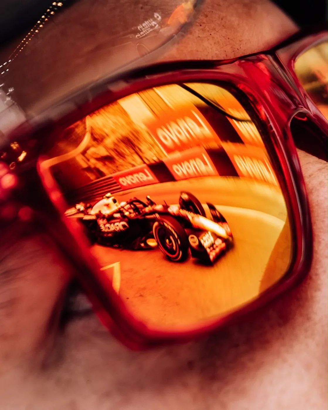 F1 car reflected in racing sunglasses